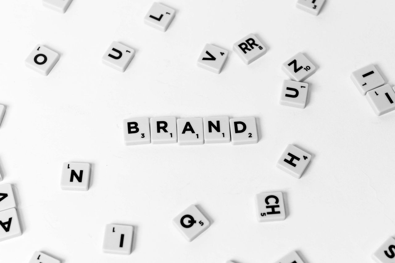 Une vue à plat de lettres éparpillées formant le mot BRAND sur un fond blanc.
